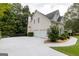 View of the home's rear exterior, showcasing a spacious three-car garage and well-maintained grounds at 6205 Collingham Trce, Cumming, GA 30040