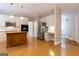 Open kitchen with a center island, stainless steel appliances, white cabinetry and hardwood floors at 6205 Collingham Trce, Cumming, GA 30040