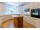 Modern kitchen with an island, white cabinets, stainless steel appliances, and hardwood floors at 6205 Collingham Trce, Cumming, GA 30040