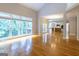 Open living room featuring hardwood floors, large windows, and an open floor plan to the kitchen at 6205 Collingham Trce, Cumming, GA 30040