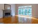 Spacious living room with hardwood floors, large windows, and a stone fireplace with a mantel at 6205 Collingham Trce, Cumming, GA 30040