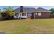 Spacious backyard with manicured lawn, screened porch, and brick detailing at 130 Gillson Dr, Mcdonough, GA 30253