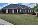 Charming brick home featuring manicured front lawn and classic black shutters at 130 Gillson Dr, Mcdonough, GA 30253