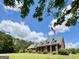 Charming brick home with dormers and American flag set on a large, well-maintained lawn under a blue sky at 238 Marks Rd, Mansfield, GA 30055