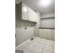 A bright laundry room featuring tile floors, storage cabinets, and washer/dryer hookups for added convenience at 238 Marks Rd, Mansfield, GA 30055