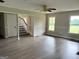 Open concept living room with hardwood floors, large windows, and views of the staircase and backyard at 238 Marks Rd, Mansfield, GA 30055