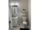 Bathroom with a white vanity, toilet, decorative shelves, and marble-look tile flooring at 690 Mcdonough Se Blvd, Atlanta, GA 30315