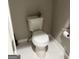 Close-up of a white toilet in a bathroom with marble-look flooring at 690 Mcdonough Se Blvd, Atlanta, GA 30315