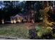 Inviting single-story home with professional lighting highlighting the landscaped yard and mature trees at 5930 Shannon Dr, Cumming, GA 30040