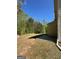 Grassy side yard with wooded area and a partial view of a patio at 5041 Cottage Grove Pl, Union City, GA 30291