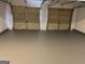 Spacious two car garage featuring gray sealed concrete floors and two white doors at 5041 Cottage Grove Pl, Union City, GA 30291