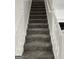 Carpeted staircase with decorative white railing leading to the upper level at 5041 Cottage Grove Pl, Union City, GA 30291