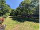 Backyard featuring lawn with mature trees and full perimeter fence at 1710 Crumbley Rd, Mcdonough, GA 30252