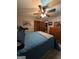 Comfortable bedroom features a ceiling fan, a bed with blue comforter, and wooden dresser at 1710 Crumbley Rd, Mcdonough, GA 30252