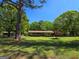 Charming ranch-style home with a lush green lawn and mature trees creating a serene landscape at 1710 Crumbley Rd, Mcdonough, GA 30252