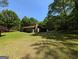 Exterior of a single-story home with a large lawn surrounded by mature trees at 1710 Crumbley Rd, Mcdonough, GA 30252