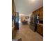 Traditional kitchen with stainless steel refrigerator, wood cabinets, and an adjacent dining area with outdoor views at 1710 Crumbley Rd, Mcdonough, GA 30252