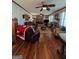 Spacious living room featuring hardwood floors, ceiling fans, a stone fireplace, and multiple seating areas at 1710 Crumbley Rd, Mcdonough, GA 30252