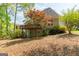 Exterior of home featuring a wood deck overlooking a spacious, tree-filled backyard with colorful landscaping at 1270 Tribble Walk Ct, Lawrenceville, GA 30045