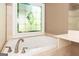 This bathroom features a jacuzzi-style tub underneath a stunning stained-glass window at 1270 Tribble Walk Ct, Lawrenceville, GA 30045