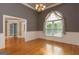 Elegant dining room featuring hardwood floors, wainscoting, chandelier and arched window with curtains at 1270 Tribble Walk Ct, Lawrenceville, GA 30045