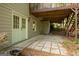 Covered patio beneath wooden deck, featuring exterior access door and stone paver flooring at 1270 Tribble Walk Ct, Lawrenceville, GA 30045