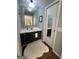 Bathroom showing vanity with dark cabinets, white countertop, and a large framed mirror at 288 Trickum Creek Rd, Tyrone, GA 30290