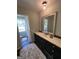 Bathroom features a vanity with black cabinets, a white countertop, and a large mirror at 288 Trickum Creek Rd, Tyrone, GA 30290