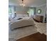 Bright primary bedroom with hardwood floors, a chandelier, and a luxurious king-sized bed at 288 Trickum Creek Rd, Tyrone, GA 30290