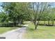 Scenic view of a long, gravel driveway lined with mature trees, leading to a secluded property in the countryside at 288 Trickum Creek Rd, Tyrone, GA 30290