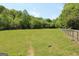 Expansive green field enclosed by a rustic wooden fence, bordered by lush trees, perfect for a countryside estate at 288 Trickum Creek Rd, Tyrone, GA 30290