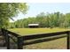 Fenced pasture with a barn and grazing animals, ideal for equestrian pursuits at 288 Trickum Creek Rd, Tyrone, GA 30290