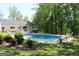 Backyard view showcasing a spacious pool with a diving board, complemented by lounge chairs and a well-maintained lawn at 288 Trickum Creek Rd, Tyrone, GA 30290
