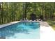 Backyard pool surrounded by mature trees, offering a private retreat with lounge chairs for relaxation at 288 Trickum Creek Rd, Tyrone, GA 30290