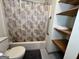 The bathroom features a tub/shower combination with a patterned shower curtain and convenient built-in shelves at 96 Daniel Ct, Mcdonough, GA 30253