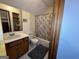 Classic bathroom with a wood vanity, white fixtures, and a shower-tub combo with decorative shower curtain at 96 Daniel Ct, Mcdonough, GA 30253