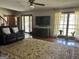 Cozy living room with a comfortable black sofa, a large rug, and natural light from the windows at 96 Daniel Ct, Mcdonough, GA 30253