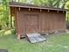 Backyard wooden shed with double doors, a ramp and brick supports at the corners at 96 Daniel Ct, Mcdonough, GA 30253