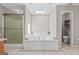 Relaxing bathroom featuring a large soaking tub, shower, skylight, and neutral walls at 3222 Bay View Dr, Jonesboro, GA 30236