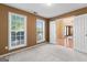 Bedroom with neutral carpet, two windows, and a view into the adjacent living area at 643 Rangeley Meadows Ct, Hampton, GA 30228