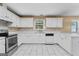 Bright kitchen with white cabinets, stainless steel appliances, and tile floors at 643 Rangeley Meadows Ct, Hampton, GA 30228
