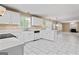 Open kitchen with white cabinets, tile floors, and view into living room with fireplace at 643 Rangeley Meadows Ct, Hampton, GA 30228