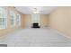 Spacious living room offers a cozy fireplace, large windows, and tile floors at 643 Rangeley Meadows Ct, Hampton, GA 30228