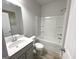 Modern bathroom with white tiled shower-tub and white vanity sink at 169 Cabin Way, Hampton, GA 30228