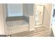 Luxurious bathroom featuring a separate shower and a soaking tub with tiled accent wall at 169 Cabin Way, Hampton, GA 30228