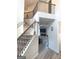 A foyer with black iron and wood railings, wood grain vinyl flooring and a fireplace at 169 Cabin Way, Hampton, GA 30228
