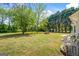Large backyard featuring a well-maintained lawn, mature trees, and a fire pit at 90 Harlin Ct, Covington, GA 30014