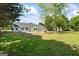 Lush backyard with mature trees, a small patio, and a view of the home's rear facade at 90 Harlin Ct, Covington, GA 30014