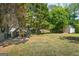 Backyard featuring a chicken coop and storage shed in the distance, surrounded by lush greenery at 90 Harlin Ct, Covington, GA 30014