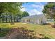 Cozy backyard with a small patio and a view of the home's exterior, surrounded by greenery at 90 Harlin Ct, Covington, GA 30014